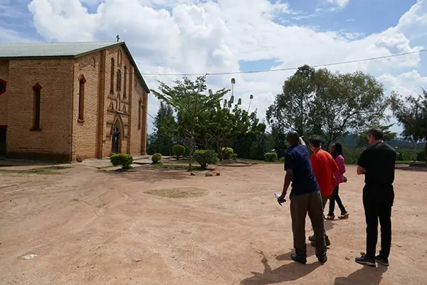 Forsvarerteamet på en åpen plass foran en murkirke i Rwanda